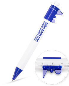 Caneta plástica paquímetro em destaque em meio a diversas ferramentas e equipamentos de escritório e design, incluindo lápis, papel, válvula, régua, entre outros.
