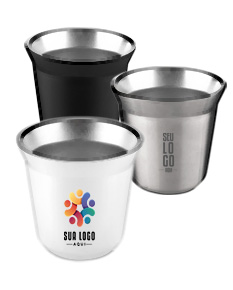 Copo térmico para espresso em cerâmica amarela, com alça e colher de metal, sobre uma mesa.