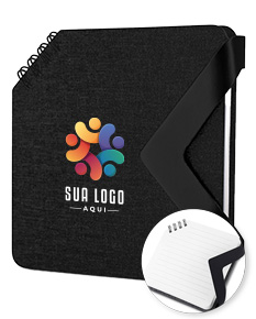 Mini caderno preto de couro aberto sobre uma mesa de escritório, ao lado de um notebook e diversos dispositivos eletrônicos. Contém páginas em branco, chave, memo, papel e ícones de segurança, representando um local para armazenar dados e informações importantes.